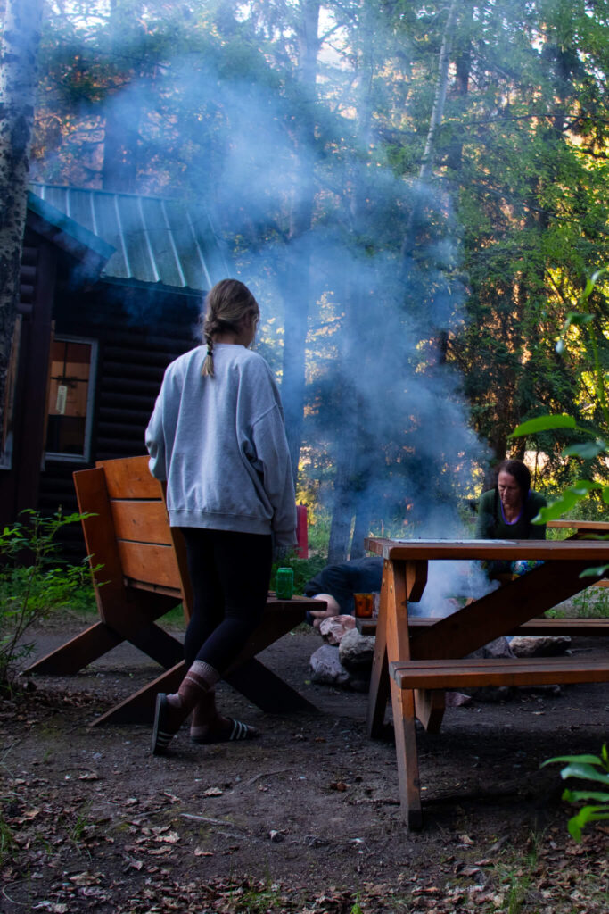 women joining a group by the firepit